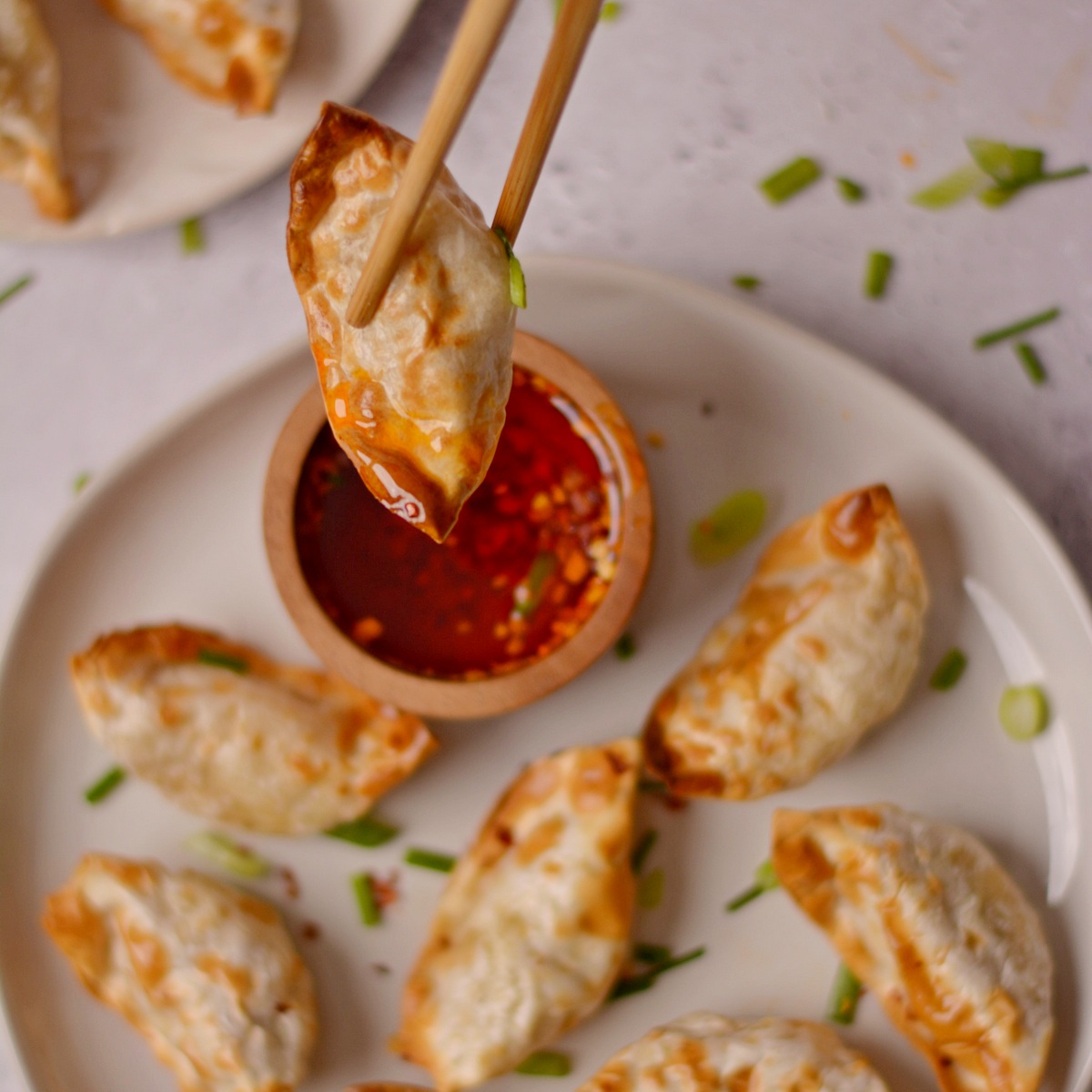 Dipping cooked gyoza from the air fryer with sauce